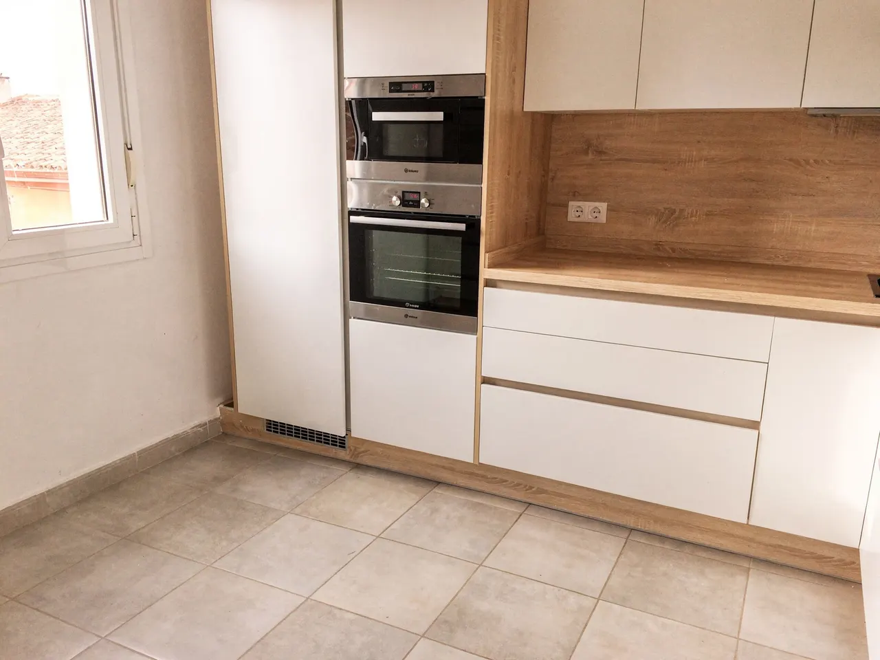 Cocina reformada con columna de hornos y encimera de madera